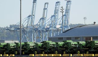 John Deere Agricultural machinery made by Deere &amp;amp; Company sits staged for transport, Friday, May 10, 2019, near cranes at the Port of Tacoma in Tacoma, Wash. U.S. and Chinese negotiators resumed trade talks Friday under increasing pressure after President Donald Trump raised tariffs on $200 billion in Chinese goods and Beijing promised to retaliate. (AP Photo/Ted S. Warren)