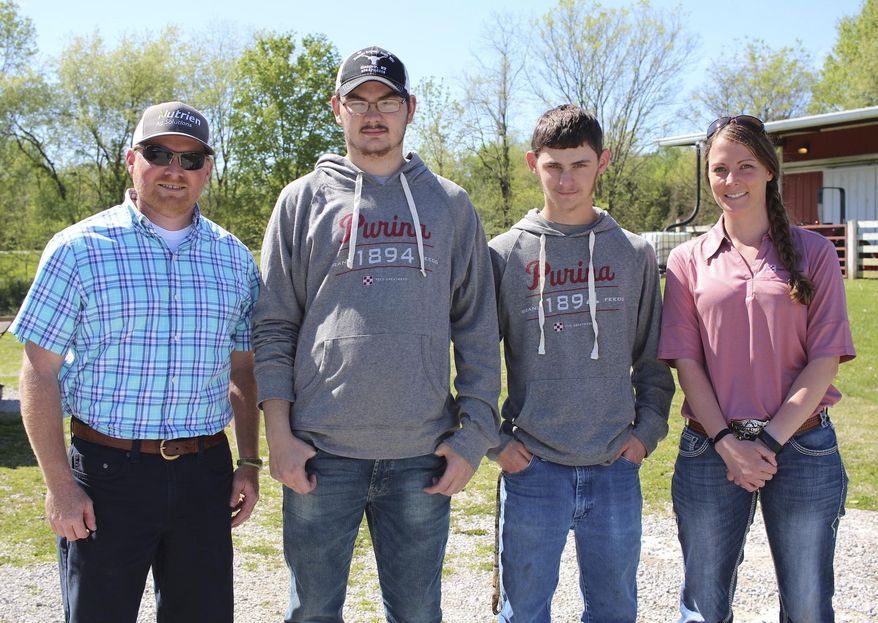 From left, Andy Moore, Barren County High School agriculture teacher; BCHS juniors Donovan London and Daylin Posey; and Katie Carrier, mid-atlantic division livestock production specialist for Purina Animal Nutrition, pose outside of BCHS, April 22, 2019, in Glasgow, Ky. BCHS agriculture students recently helped conduct a 28-day feed trial with Purina Animal Nutrition. (Will Perkins/The Daily Times via AP)
