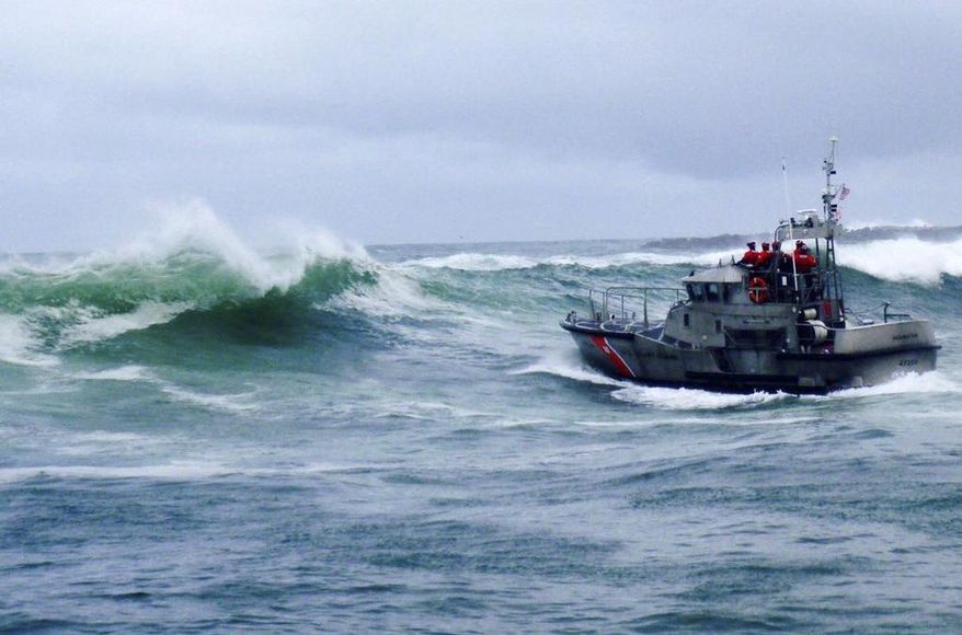 FILE - In this Tuesday, Jan. 8, 2019 file photo, provided by the U.S. Coast Guard, a U.S. Coast Guard boat crew responds to three fishermen in the water after the commercial fishing vessel Mary B II capsized while crossing Yaquina Bay Bar off the coast of Newport, Ore. The U.S. Coast Guard is holding a public hearing Monday, May 13, 2019, n Newport, Oregon to review its handling of a crab boast sinking that killed 3 crabbers off the Oregon coast earlier this year. (U.S. Coast Guard via AP, File)