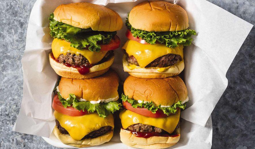 This undated photo provided by America's Test Kitchen in May 2019 shows Classic Beef Burgers in Brookline, Mass. This recipe appears in the cookbook "The Ultimate Burger." (Daniel J. van Ackere/America's Test Kitchen via AP)