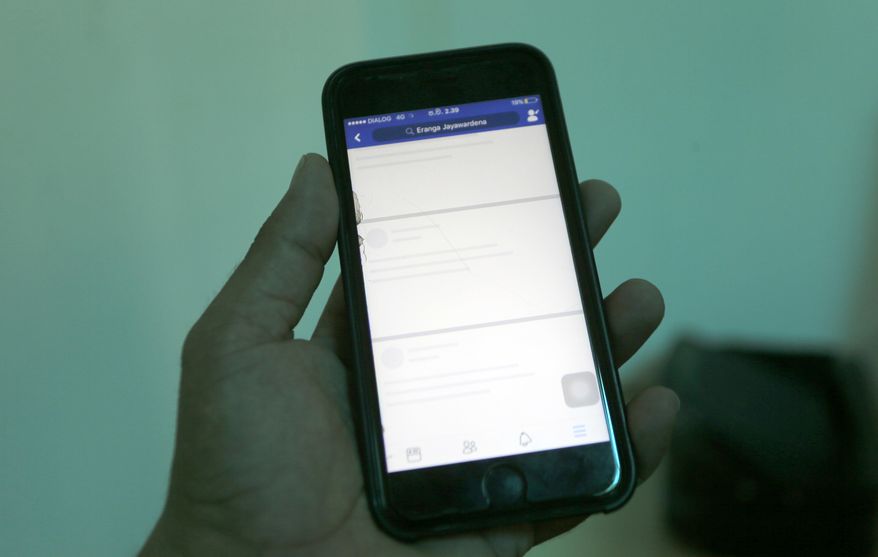 FILE- In this March 7, 2018 file photo, a blocked Facebook window is seen on a smart phone screen in Colombo, Sri Lanka. Sri Lanka's government has temporarily blocked social media and messaging apps following a flare-up of communal violence, the third time it has taken such a step since last month's Easter attacks that killed more than 250 people, an official said Monday. (AP Photo/Eranga Jayawardena, File)
