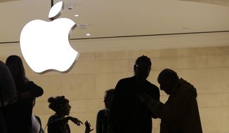 In this May 31, 2018, file photo customers enter the Apple store in New York. (AP Photo/Mark Lennihan, File)