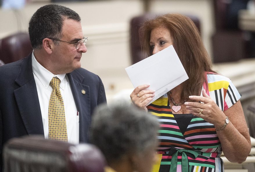 Rep. Terri Collins, right, chats with Rep. Chris Pringle on the house floor at the Alabama Statehouse in Montgomery, Ala., on Tuesday, May 14, 2019. (Mickey Welsh/Montgomery Advertiser via AP)