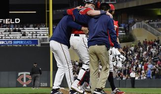 Minnesota Twins&#39; catcher Mitch Garver is helped off the field after he was injured tagging out Los Angeles Angels&#39; Shohei Ohtani as he attempted to score from second base on a hit by Brian Goodwin in the eighth inning of a baseball game Tuesday, May 14, 2019, in Minneapolis. The Twins won 4-3. (AP Photo/Jim Mone)