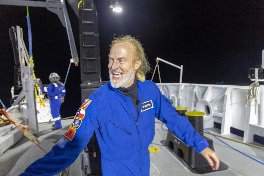 In this photo provided by Atlantic Productions for Discovery Channel, Victor Vescovo emerges from his submersible 'Limiting Factor' after a successful dive to the deepest known point in the Mariana Trench, April 28, 2019. Vescovo, a businessman and amateur pilot, has also traversed the highest peaks of mountains, including Mount Everest. (Tamara Stubbs/Atlantic Productions for Discovery Channel via AP)