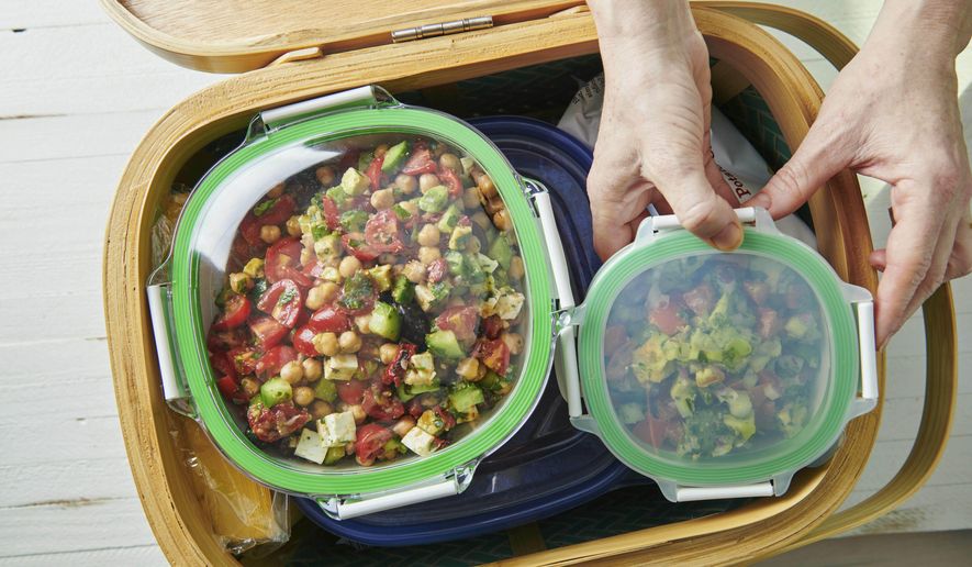 This May 2019 photo shows containers being packed in a picnic basket in New York. Whether it's a simple al fresco lunch or a romantic repast for two, a successful picnic takes planning. Make a checklist and gather ideas for which foods work best. (Cheyenne Cohen/Katie Workman via AP)