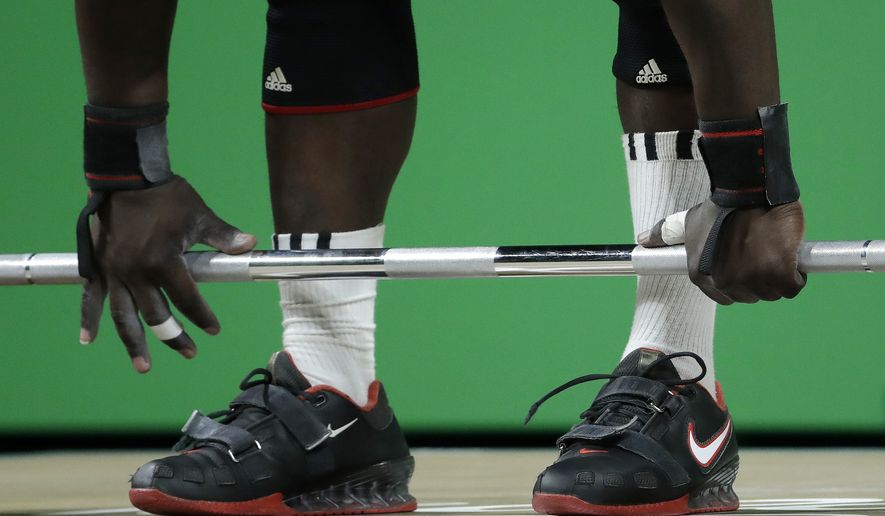 James Adede, of Kenya, gets a grip on the barbell before attempting a lift in the men&#39;s 94kg weightlifting competition at the 2016 Summer Olympics in Rio de Janeiro, Brazil, Saturday, Aug. 13, 2016. (AP Photo/Mike Groll) **FILE**

