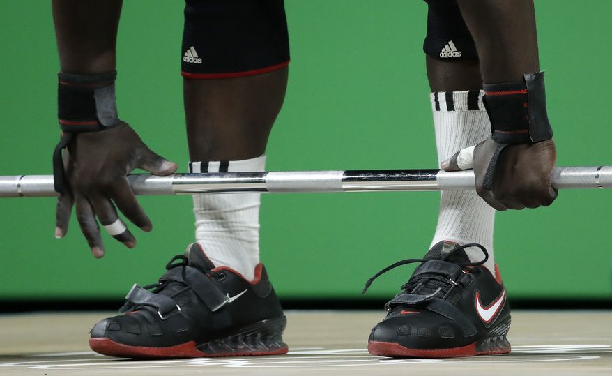 James Adede, of Kenya, gets a grip on the barbell before attempting a lift in the men's 94 kg weightlifting competition at the 2016 Summer Olympics in Rio de Janeiro, Brazil, Saturday, Aug. 13, 2016. (AP Photo/Mike Groll) **FILE**