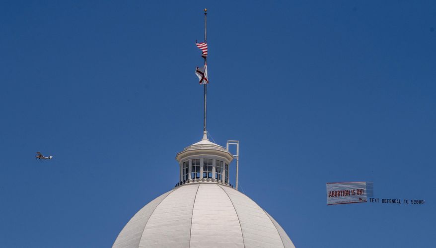Legal abortion supporters fly a banner reading Abortion is OK over the Alabama State Capitol building in downtown Montgomery, Ala., on Wednesday May 15, 2019. Alabama HB314, the near-total ban on abortion bill, passed the Alabama legislature on Tuesday. (Mickey Welsh/The Montgomery Advertiser via AP)
