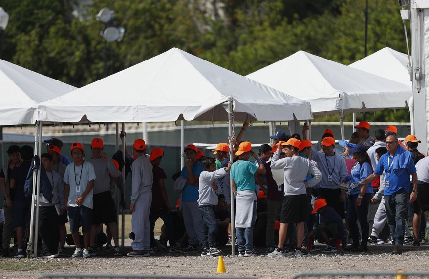 FILE - In this Monday, May 6, 2019 file photo, migrant children stand outside the Homestead Temporary Shelter for Unaccompanied Children in Homestead, Fla. The U.S. government is providing long-distance video counseling to teens housed at the country's largest migrant detention center as officials struggle to accommodate increasing numbers of minors illegally crossing the U.S.-Mexico border. Some mental health experts and human rights advocates say that may not be the best way to help young people coping with trauma. (AP Photo/Wilfredo Lee, File)