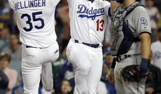 Los Angeles Dodgers&#39; Cody Bellinger (35) celebrates his two-run home run at home plate with teammate Max Muncy (13) next to San Diego Padres catcher Austin Hedges during the third inning of a baseball game Tuesday, May 14, 2019, in Los Angeles. (AP Photo/Marcio Jose Sanchez)