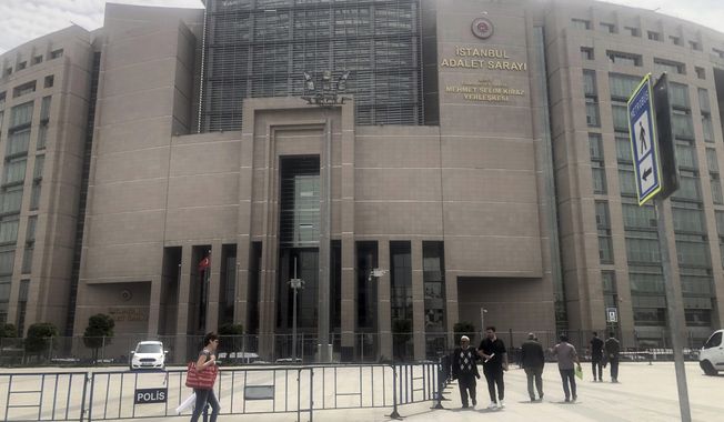 In this file photo, people walk to the main Justice Palace in Istanbul, Wednesday, May 15, 2019, as the trial begins against Metin Topuz, a Turkish employee of the United States Consulate in Istanbul charged with espionage and attempting to overthrow the Turkish government. Mr. Topuz was convicted on June 11, 2020.  (AP Photo/Mehmet Guzel)