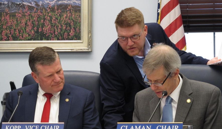 Buddy Whitt, center, a legislative aide, speaks with Alaska state Representatives, Chuck Kopp, left, and Matt Claman at the start of a conference committee meeting on crime legislation in Juneau, Alaska, Thursday, May 16, 2019. Alaska House and Senate negotiators have reached agreement on a sweeping crime package that one member says would repeal and replace a 2016 criminal justice overhaul. The bill is intended to address public outcry over crime. The full House and Senate will still need to OK the package. A final vote is expected in the coming days. (AP Photo/Becky Bohrer)
