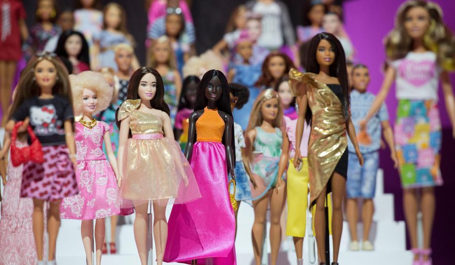 FILE- In this Feb. 20, 2018, file photo dozens of Barbie dolls are displayed at the Mattel showroom at Toy Fair in New York. The Council of Fashion Designers of America will present its Board of Directors’ Tribute Award to the ever-evolving Barbie doll. The council said in a statement Thursday the idea is to celebrate Barbie as a fashion icon, coinciding with her 60th anniversary. (AP Photo/Mark Lennihan, File)
