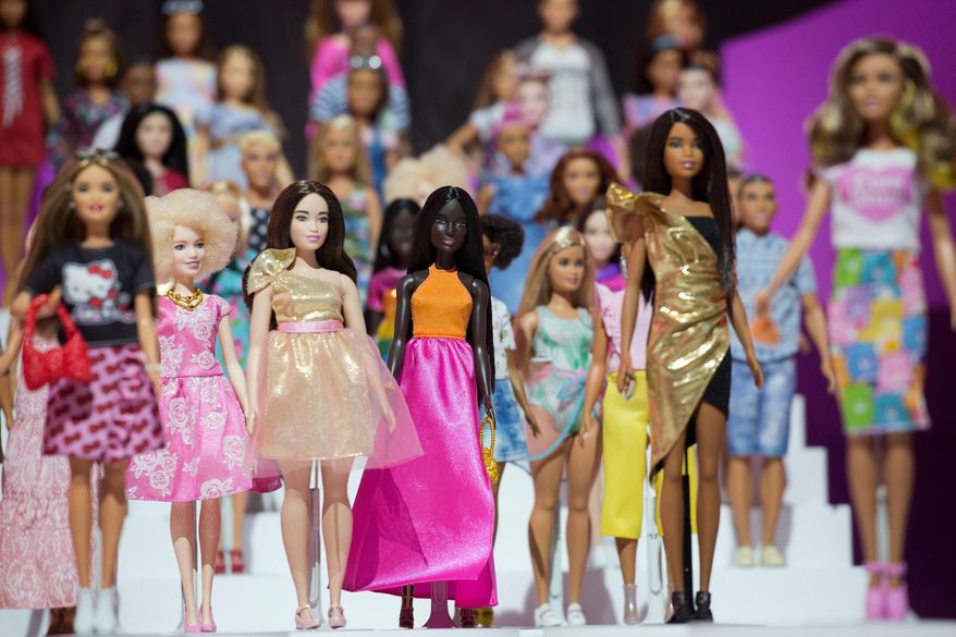 FILE- In this Feb. 20, 2018, file photo dozens of Barbie dolls are displayed at the Mattel showroom at Toy Fair in New York. The Council of Fashion Designers of America will present its Board of Directors’ Tribute Award to the ever-evolving Barbie doll. The council said in a statement Thursday the idea is to celebrate Barbie as a fashion icon, coinciding with her 60th anniversary. (AP Photo/Mark Lennihan, File)