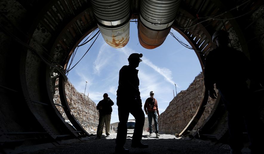 FILE - In this April 9, 2015, file photo, people walk into the south portal of Yucca Mountain during a congressional tour of the proposed radioactive waste dump near Mercury, Nev., 90 miles northwest of Las Vegas. Elected officials in rural Nye County say they support moving forward with a long-studied but mothballed national nuclear waste repository in Nevada, unlike their counterparts in approximately 90 miles away in Las Vegas. But the Las Vegas Sun reports those who live near the Yucca Mountain site are split on whether storing approximately 70,000 tons of nuclear waste there is a good idea. (AP Photo/John Locher, File)