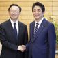 Chinese State Councilor Yang Jiechi, left, and Japanese Prime Minister Shinzo Abe, right, shake hands at Abe&#39;s official residence in Tokyo Friday, May 17, 2019. (AP Photo/Eugene Hoshiko, Pool)