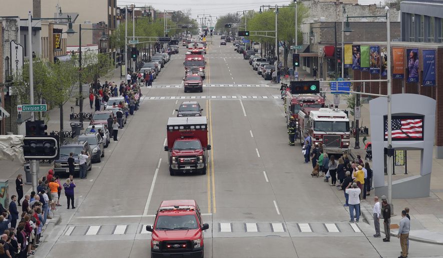 In this Thursday, May 16, 2019 photo, a procession for firefighter Mitch Lundgaard who was shot and killed while responding to a medical call at the Valley Transit Center moves along College Avenue in Appleton, Wis. (Dan Powers/The Post-Crescent via AP)