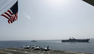 In this Friday, May 17, 2019, photo, released by the U.S. Navy, the amphibious assault ship USS Kearsarge, right, and the Arleigh Burke-class guided-missile destroyer USS Bainbridge, left, are seen from the Nimitz-class aircraft carrier USS Abraham Lincoln as they sail in the Arabian Sea. Commercial airliners flying over the Persian Gulf risk being targeted by &quot;miscalculation or misidentification&quot; from the Iranian military amid heightened tensions between the Islamic Republic and the U.S., American diplomats warned Saturday, May 19, 2019, even as both Washington and Tehran say they don&#39;t seek war. (Mass Communication Specialist Seaman Michael Singley, U.S. Navy via AP)