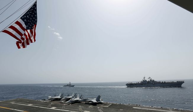 In this Friday, May 17, 2019, photo, released by the U.S. Navy, the amphibious assault ship USS Kearsarge, right, and the Arleigh Burke-class guided-missile destroyer USS Bainbridge, left, are seen from the Nimitz-class aircraft carrier USS Abraham Lincoln as they sail in the Arabian Sea. Commercial airliners flying over the Persian Gulf risk being targeted by &quot;miscalculation or misidentification&quot; from the Iranian military amid heightened tensions between the Islamic Republic and the U.S., American diplomats warned Saturday, May 19, 2019, even as both Washington and Tehran say they don&#x27;t seek war. (Mass Communication Specialist Seaman Michael Singley, U.S. Navy via AP)