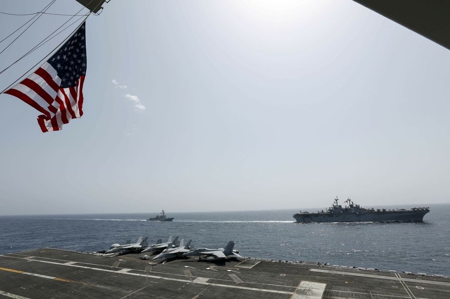 In this Friday, May 17, 2019, photo, released by the U.S. Navy, the amphibious assault ship USS Kearsarge, right, and the Arleigh Burke-class guided-missile destroyer USS Bainbridge, left, are seen from the Nimitz-class aircraft carrier USS Abraham Lincoln as they sail in the Arabian Sea. Commercial airliners flying over the Persian Gulf risk being targeted by "miscalculation or misidentification" from the Iranian military amid heightened tensions between the Islamic Republic and the U.S., American diplomats warned Saturday, May 19, 2019, even as both Washington and Tehran say they don't seek war. (Mass Communication Specialist Seaman Michael Singley, U.S. Navy via AP)