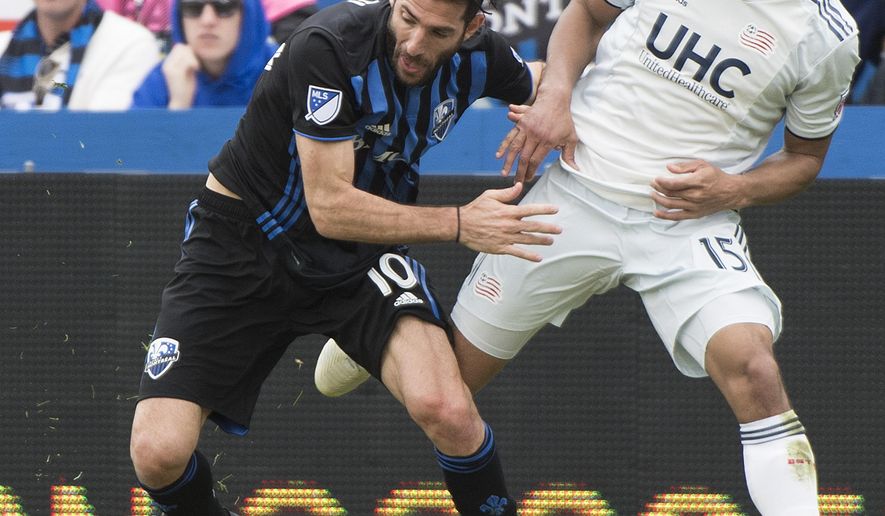 Montreal Impact&#39;s Ignacio Piatti, left, shields the ball from New England Revolution&#39;s Brandon Bye (15) during the second half of an MLS soccer game in Montreal, Saturday, May 18, 2019. (Graham Hughes/The Canadian Press via AP)