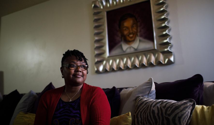 Octavia Mitchell poses for a portrait in her home near a painting of her son, Izael Jackson, Thursday May 2, 2019, in Chicago. He was fatally shot by police in 2010 and Mitchell says she’s working with police regulators to reopen his case. (Armando L. Sanchez/Chicago Tribune via AP)