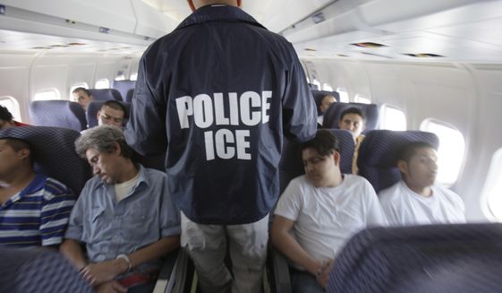 In this May 25, 2010 file photo, an Immigration and Customs Enforcement agent walks down the aisle among shackled Mexican immigrants a boarded a U.S. Immigration and Customs Enforcement charter jet for deportation in the air between Chicago, Il. and Harlingen, Texas. A Homeland Security Department internal watchdog says U.S. Immigration and Customs Enforcement could have saved millions of dollars on charter flights carrying deported immigrants to their home countries by not leaving seats empty. (AP Photo/LM Otero, File)