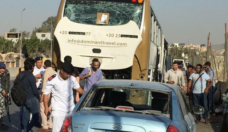 Police inspect a car and a bus that were damaged by a bomb, in Cairo, Egypt, Sunday, March 19, 2019. Egyptian officials say a roadside bomb has hit a tourist bus near the Giza Pyramids. They said Sunday’s blast wounded at least 17 people including tourists. (AP Photo/Mohammed Salah)
