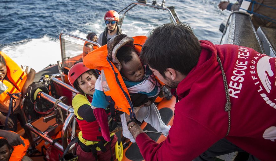 A baby is loaded into the rescue vessel of the Spanish NGO Proactiva Open Arms, after being rescued in the Central Mediterranean Sea at 45 miles from Al Khums, Libya. (AP Photo/Olmo Calvo, File)