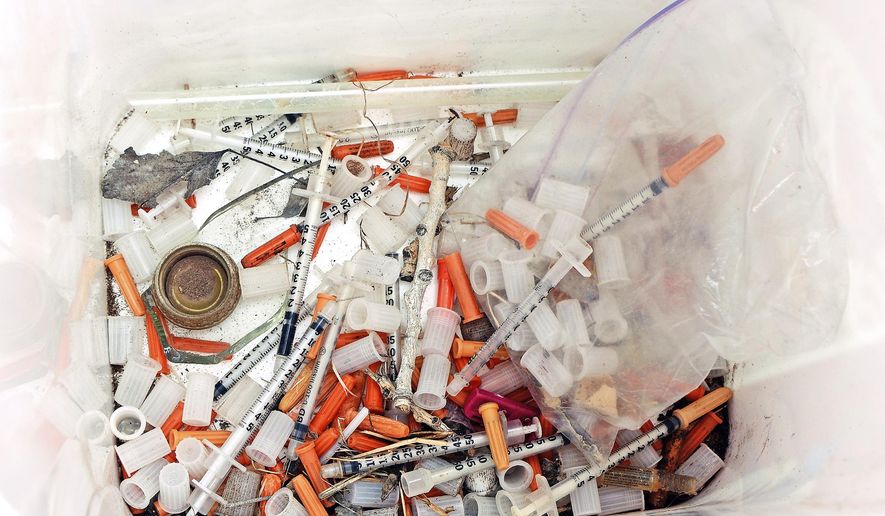 This May 8, 2019, photo shows hypodermic needles, needle caps, cotton swabs and other drug paraphernalia removed from Atrisco Park, home of the Atrisco Valley Little League, in Albuquerque, N.M. The little league park is fighting a battle against discarded syringes with attached hypodermic needles amid the region’s outgoing opioid epidemic. (Jim Thompson/The Albuquerque Journal via AP)