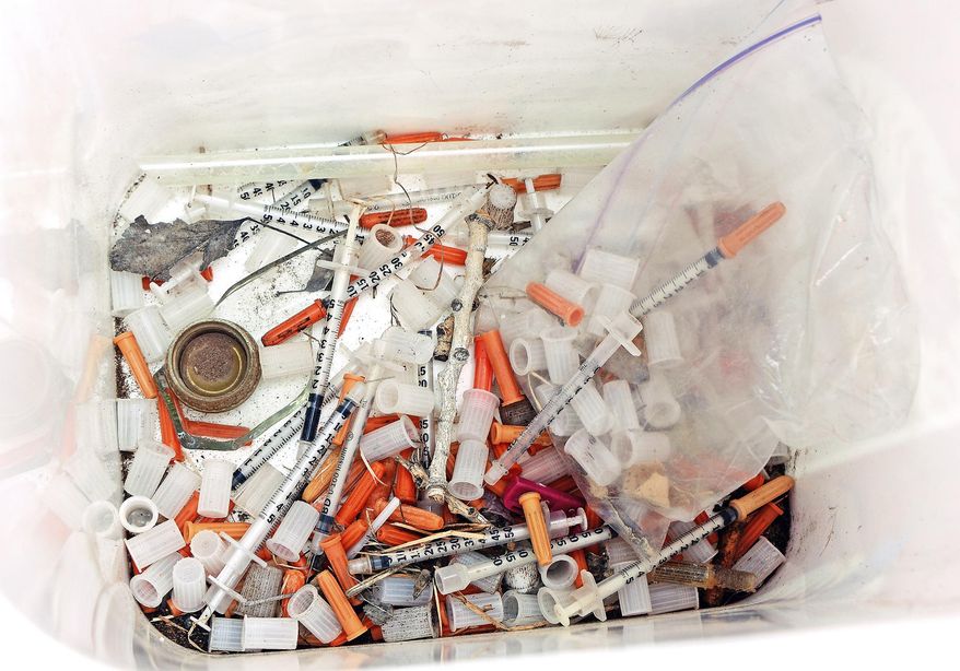 This May 8, 2019, photo shows hypodermic needles, needle caps, cotton swabs and other drug paraphernalia removed from Atrisco Park, home of the Atrisco Valley Little League, in Albuquerque, N.M. The little league park is fighting a battle against discarded syringes with attached hypodermic needles amid the region’s outgoing opioid epidemic. (Jim Thompson/The Albuquerque Journal via AP)