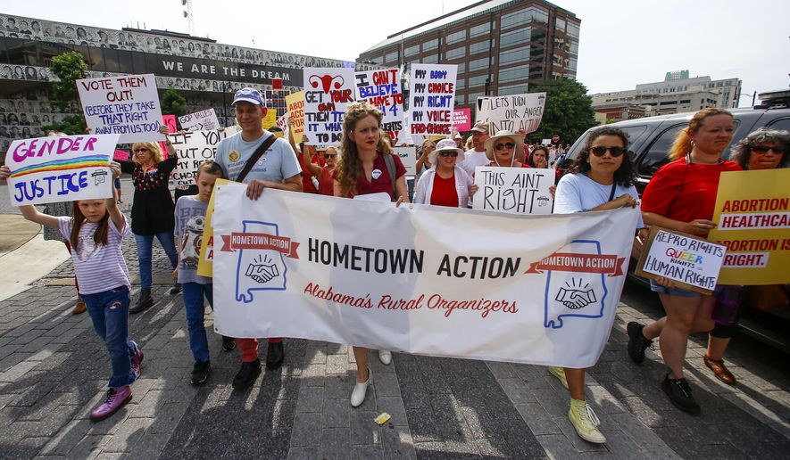 Protesters for women's rights march to the Alabama Capitol to protest a law passed last week making abortion a felony in nearly all cases with no exceptions for cases of rape or incest, Sunday, May 19, 2019, in Montgomery, Ala. (AP Photo/Butch Dill)