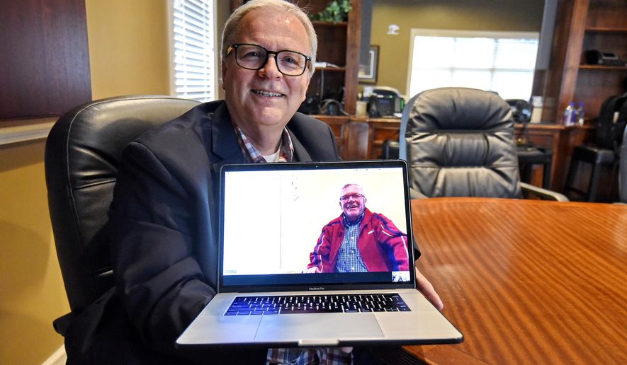 In this Wednesday, May 8, 2019, photo, Allen Henderson, General Manager of HIS Radio Station in Greenville, S.C., speaks via Skype to his brother Andre Gantois who is in France. Henderson took a DNA test on a whim, because the company had a special offer on its prices and learned he had a half-brother in France. (AP Photo/Richard Shiro)