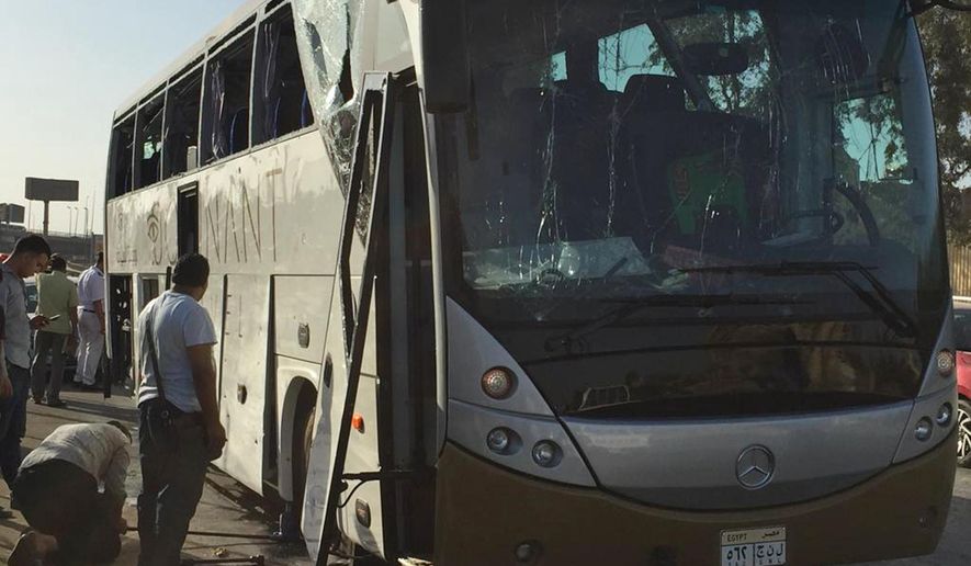 Officials jack up a bus that was damaged by a bomb, in Cairo, Egypt, Sunday, March 19, 2019. Egyptian officials say a roadside bomb has hit a tourist bus near the Giza Pyramids. They said Sunday’s blast wounded at least 17 people including tourists. (AP Photo/Mohammed Salah)