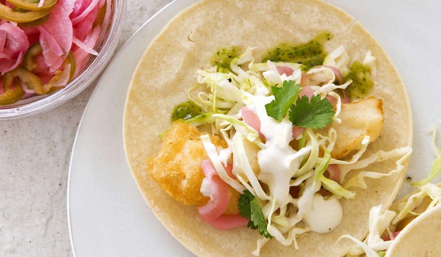 This undated photo provided by America's Test Kitchen in May 2019 shows California-Style Fish Tacos in Brookline, Mass. This recipe appears in the cookbook “New Essentials.” (Joe Keller/America's Test Kitchen via AP)