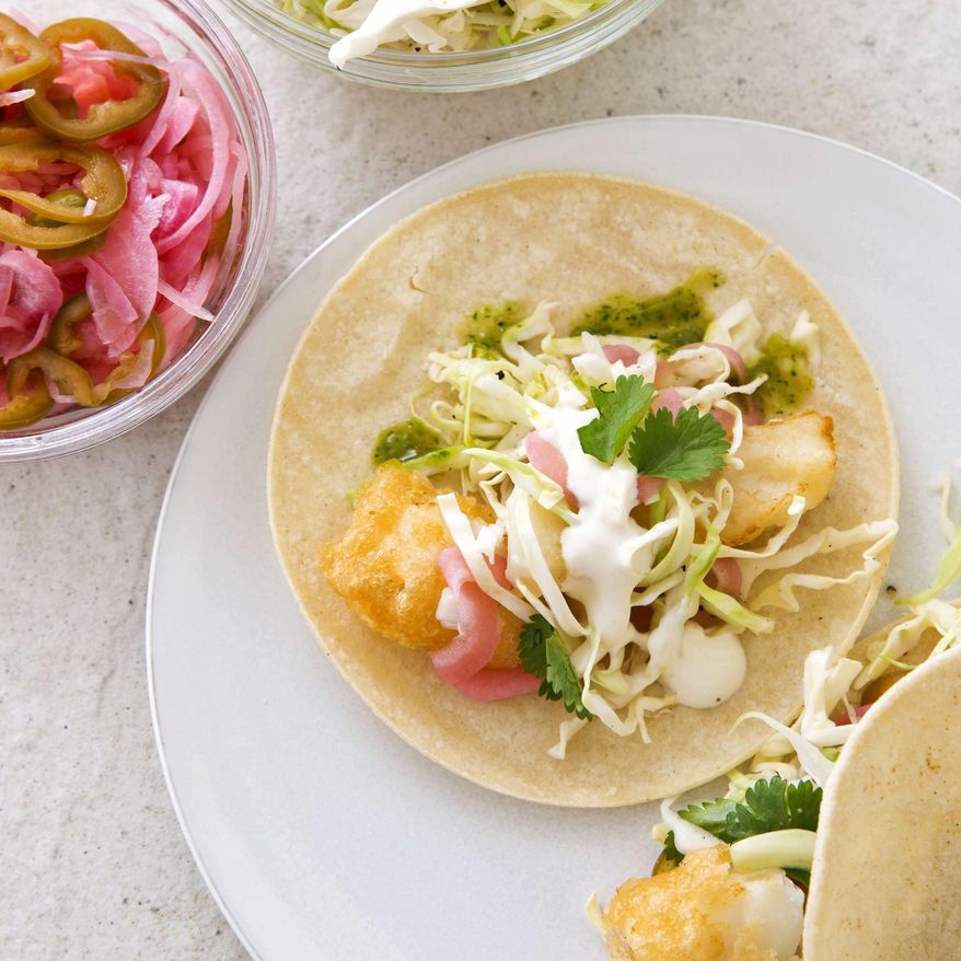 This undated photo provided by America's Test Kitchen in May 2019 shows California-Style Fish Tacos in Brookline, Mass. This recipe appears in the cookbook “New Essentials.” (Joe Keller/America's Test Kitchen via AP)