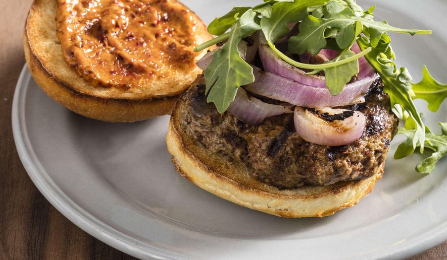 This undated photo provided by America's Test Kitchen in May 2019 shows Grilled Harissa Lamb Burgers in Brookline, Mass. This recipe appears in the cookbook “The Ultimate Burger.” (Daniel J. van Ackere/America's Test Kitchen via AP)