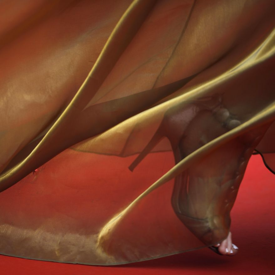 In this Tuesday, May 14, 2019 photo, a woman walks along the red carpet upon her arrival for the opening ceremony and the premiere of the film 'The Dead Don't Die' at the 72nd international film festival, Cannes, southern France. (AP Photo/Petros Giannakouris)