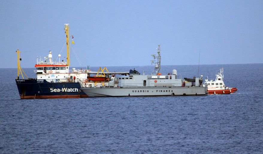 In this Sunday, May 19, 2019 photo, a Guardia di Finanza patrol boat approaches the German aid group ship Sea-Watch 3 in the waters off the Sicilian island of Lampedusa, southern Italy. Italy's hard-line Interior Minister Matteo Salvini threatened possible legal action Monday, May 20, 2019 after 47 migrants rescued at sea by the humanitarian aid ship landed on the southern Italian island of Lampedusa on Sunday evening with the cooperation of the Coast Guard and financial police despite his explicit ban against them. (Elio Desiderio/ANSA via AP)