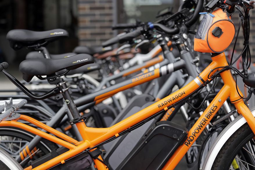 In this photo taken Wednesday, May 15, 2019, electric bicycles are lined up outside Rad Power Bikes in Seattle, where the bicycle company said that they will absorb 100% of any tariff on their Chinese-made bicycles. The District Department of Transportation has allocated $500,000 to help Washington, D.C. residents purchase their own electric bikes. (AP Photo/Elaine Thompson)