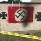 In this July 30, 2018, file photo, a garbage shed spraypainted by vandals with a Nazi flag and iron crosses stands on the grounds of the Congregation Shaarey Tefilla synagogue in the Indianapolis suburb of Carmel, Ind. (Justin Mack/The Indianapolis Star via AP, File) ** FILE **