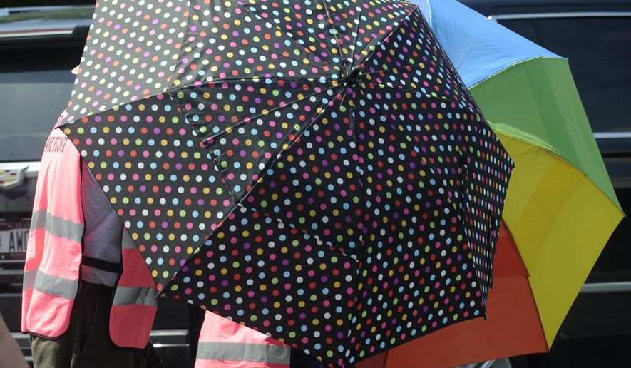 Escorts, using umbrellas, shield clients from the gestures and voices of anti-abortion activists standing on the sidewalk in front of the Alabama Women's Wellness Center Friday, May 17, 2019 in Huntsville, Ala. The Alabama legislation signed into law Wednesday would make performing or attempting to perform an abortion at any stage of pregnancy a felony. The ban does not allow exceptions for rape and incest.(AP Photo/Eric Schultz)