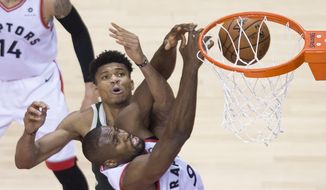 Toronto Raptors center Serge Ibaka battles for the ball against Milwaukee Bucks forward Giannis Antetokounmpo during the second half of Game 4 of the NBA basketball playoffs Eastern Conference finals, Tuesday, May 21, 2019, in Toronto. (Nathan Denette/The Canadian Press via AP) **FILE**