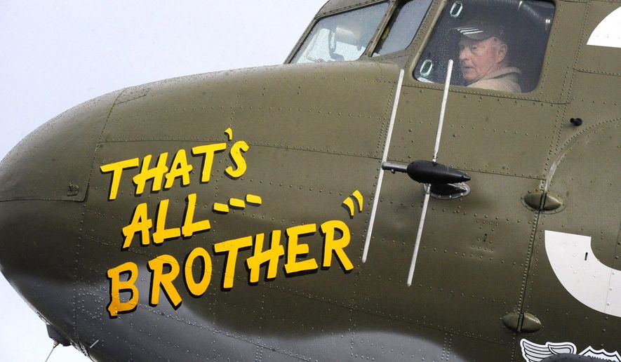 In this April 9, 2019, photo, Pilot Tom Travis sits in the cockpit of the World War II troop carrier That's All, Brother during a stop in Birmingham, Ala. The C-47 aircraft, which led the main Allied invasion of Europe on June 6, 1944, is returning to the continent to participate in events marking the 75th anniversary of D-Day in June. (AP Photo/Jay Reeves)
