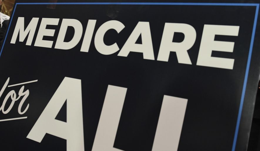 In this April 10, 2019, file photo, a sign is shown during a news conference to reintroduce &amp;quot;Medicare for All&amp;quot; legislation, on Capitol Hill in Washington. The “Medicare for All” proposal from leading Democrats running for president appears more lavish than what’s offered in other advanced countries. (AP Photo/Susan Walsh, file)