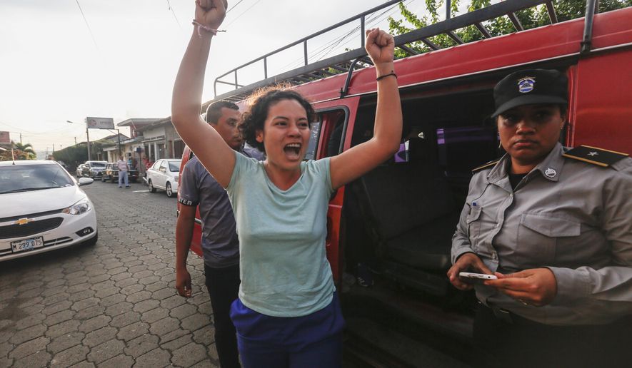 Opposition member María Adilia Peralta Cerratos raises her arms in jubilation as she returns home after being in prison, in Masaya, Nicaragua, Monday, May 20, 2019. Peralta Cerratos is one of 100 prisoners the Nicaraguan government released Monday in a form of house arrest, including three human rights activists. (AP Photo/Alfredo Zuniga)