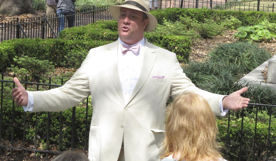 FILE - In this Friday, March 20, 2015 file photo, Dan Leger, who works under the name Savannah Dan, talks with visitors while leading a guided tour of downtown Savannah, Ga. A federal judge says the city of Savannah violated the free-speech rights of tour guides by requiring them to obtain a license under a local law that has since been scrapped. The ruling Monday, May 21, 2019 in U.S. District Court is largely a symbolic victory for Savannah tour guides who sued City Hall more than four years ago over the 1978 licensing ordinance. (AP Photo/Russ Bynum, File)