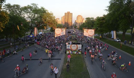 Cyclists get underway in Tour la Nuit, the annual Montreal bicycle festival&#39;s night ride, June 3, 2016. This year, on May 31, the crowd of some 10,000 will bicycle into and around Montreal&#39;s Olympic Stadium as part of the night tour. Montreal is a hotbed of cycling, with plentiful urban paths and access to long-distance touring routes and one of Canada&#39;s longest rail trails outside the city. (AP Photo/Cal Woodward)