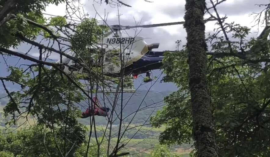 This Tuesday, May 21, 2019, image from video released by the California Highway Patrol, shows the scene where a woman was rescued after the car she was driving plunged 450 feet down a cliff and a bicyclist just happened to witness the accident in Napa, Calif. Authorities say the car could have fallen another 800 feet on Tuesday but it hit a tree that stopped it. A California Highway Patrol flight officer tells the San Francisco Chronicle it's likely no one would have seen the wreck on the forested mountainside in the city of Napa if the bicyclist had not been nearby. (California Highway Patrol via AP)